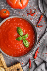 Bowl with delicious tomato soup on grunge background, closeup