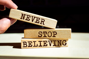 Wooden blocks with words 'Never Stop Believing'.