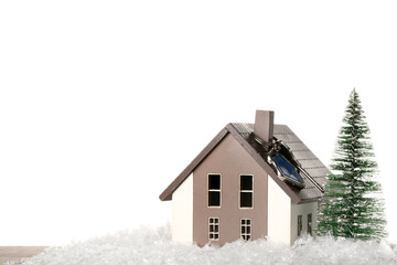 House model with key, Christmas tree and snow on table against white background