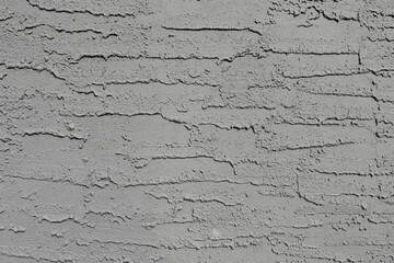An abstract image of the texture of an old grey stucco wall.