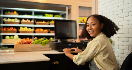 Portrait of a black african american woman working on cashier in a supermarket or retail shop and...