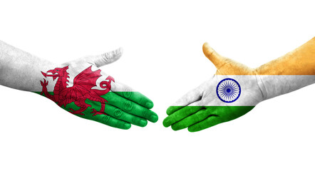 Handshake between India and Wales flags painted on hands, isolated transparent image.