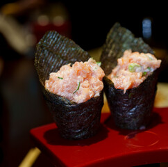 Dois te maki colocados no suporte sobre a mesa do restaurante. Comida japonesa. 