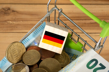 Ein Einkaufswagen, Euro Münzen und Flagge von Deutschlad