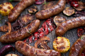 Grilled sausages and vegetables on a grill frying pan on a domestic kitchen