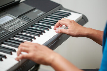 Obraz na płótnie Canvas Close-up of male hands playing keyboard
