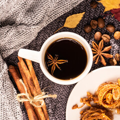Autumn concept, top view. A cup of coffee, a sweater, a star ani. A cozy winter morning with a cup of coffee with cinnamon, star anise, a cozy sweater. Selective focus.
