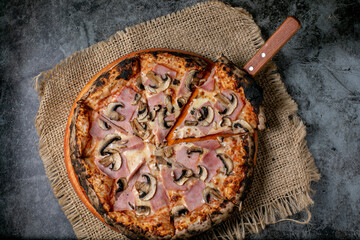 Pizza estilo napolitana - toscana cocida al horno de leña
Pizza en rodajas con queso mozzarella,...