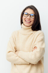 portrait of a beautiful cute woman in a beige sweater on a light background in glasses for vision...