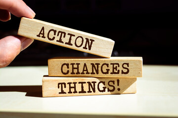 Wooden blocks with words 'Action Changes Things'.