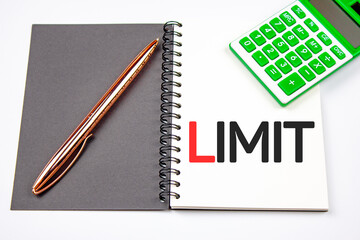 LIMIT text on notepad next to calculator and pen. Calculation of a limited amount of funds.