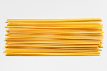 Durum fettuccine pasta on white background. Raw spaghetti or noodles