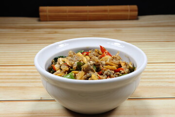 Traditional fried spicy clam meat mixed with basil and chilly serving in the bowl. 