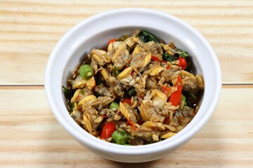 Traditional fried spicy clam meat mixed with basil and chilly serving in the bowl. 