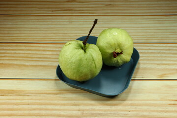 Pile of fresh and organic guava serving on the plate. Mock up of traditional tropical fruit product in Asia market.