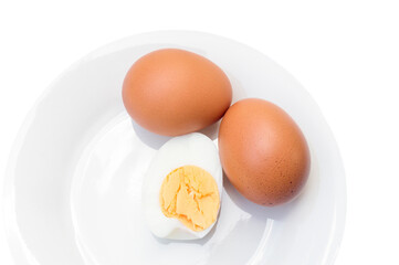 Close up of two boiled chicken eggs with peeled half on white plate is isolated on white background with clipping path, Selective focus photo