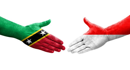 Handshake between Indonesia and Saint Kitts and Nevis flags painted on hands, isolated transparent image.