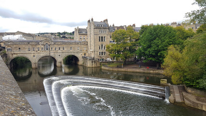 Naklejka premium A view Pulteney Bridge, weir and houses on the River Avon showcasing beautiful Georgian architecture in historic City of Bath, Somerset, England