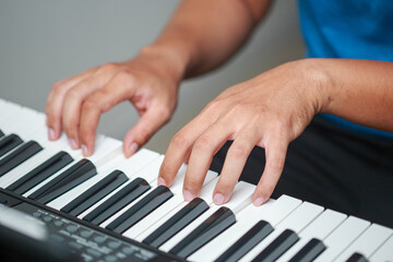 Obraz premium Man playing Electronic piano keyboard. Closeup of black and white piano keys.