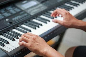 Fototapeta na wymiar Man playing Electronic piano keyboard. Closeup of black and white piano keys.