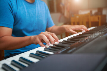 Fototapeta premium Man playing Electronic piano keyboard. Closeup of black and white piano keys.
