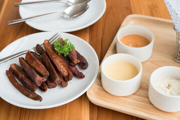 Fried sweet purple potato food, fried Japanese purple sweet potato with dips in a wooden tray