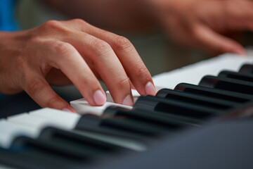 Obraz premium Man playing Electronic piano keyboard. Closeup of black and white piano keys.