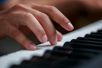 Fototapeta premium Man playing Electronic piano keyboard. Closeup of black and white piano keys.