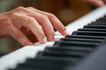 Man playing Electronic piano keyboard. Closeup of black and white piano keys.
