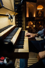 Close-up of a organist playing organ keyboard in church