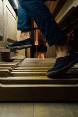 Close-up of a organist playing organ pedals in church