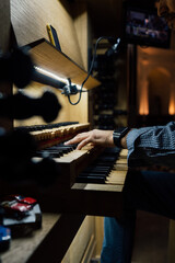 Close-up of a organist playing organ keyboard in church