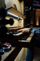 Close-up of a organist playing organ keyboard in church