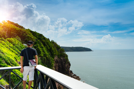 Man tourist to stand alone to see view at the terrace that extended from cliff of with mountain,sea and sunlight background at sky view cafe,Ko Proet sub district,Laem Sing, Chanthaburi,Thailand.