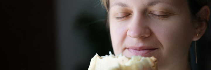 Happy woman with closed eyes holding white bread
