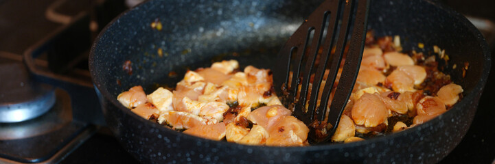 Pieces of pork or chicken with onions are fried in pan