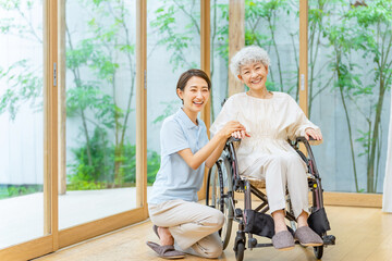 車椅子のシニア女性と介護士
