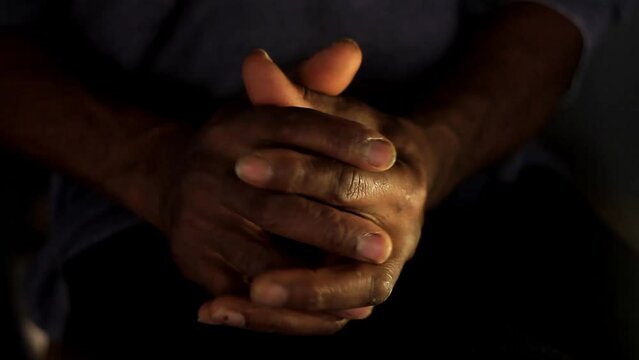 praying to god with hands together Caribbean man praying with dark background stock video