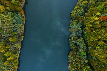 Colorful aerial view of Secu Lake in Caras-Severin - Romania, in the autumn, at sunrise, with visible access road. Scene captured from above, with a drone.