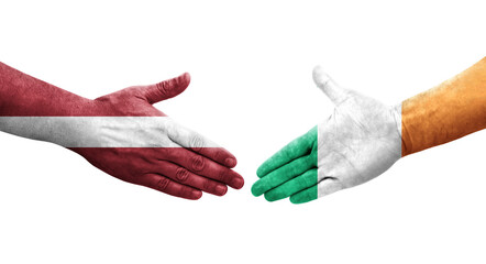 Handshake between Ireland and Latvia flags painted on hands, isolated transparent image.