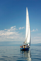 Naklejka premium Sailing yacht on a sunny calm day at sea. Activity, sports and recreation. Beautiful landscape. Vertical.