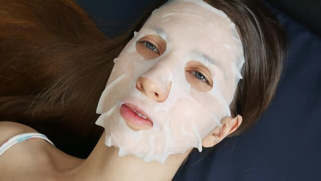 Close-up of a cute girl with a white cosmetic mask on her face