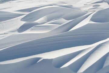 Snow drifts in the sunlight.