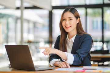 Fototapeta premium business woman or accountant who are using a calculator to calculate business data Accounting documents and laptop computer at the office business idea