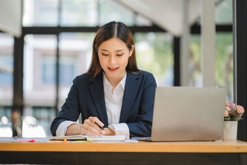 Fototapeta premium business woman or accountant who are using a calculator to calculate business data Accounting documents and laptop computer at the office business idea