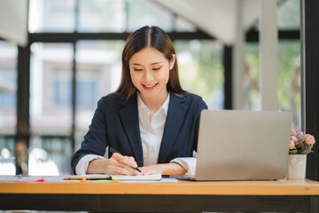 Fototapeta na wymiar business woman or accountant who are using a calculator to calculate business data Accounting documents and laptop computer at the office business idea