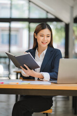 business woman or accountant who are using a calculator to calculate business data Accounting documents and laptop computer at the office business idea