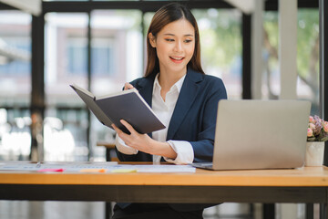 business woman or accountant who are using a calculator to calculate business data Accounting documents and laptop computer at the office business idea