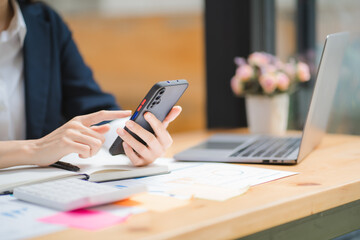 Young asian businesswoman beautiful charming smiling and talking on the mobile phone in the office