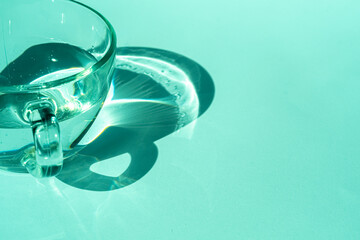 Abstract shadow pattern on white background and glass cup with water. Texture for the background.